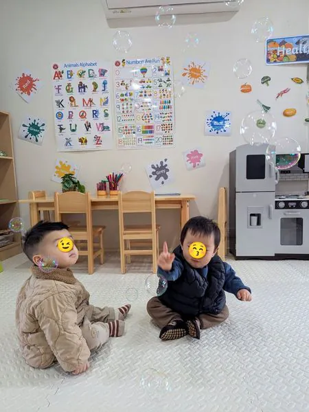 Toddlers watching bubbles float in the play room