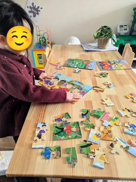 A child putting together jigsaw puzzles at the table