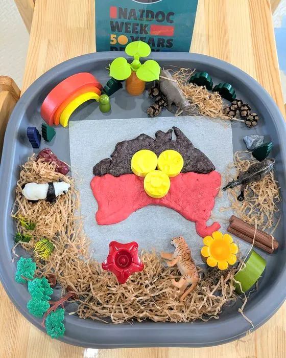 A NAIDOC Week sensory tray with an Aboriginal flag made of play dough